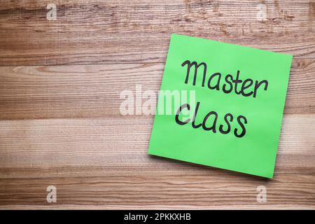 Green paper note with words Master Class on wooden table, top view. Space for text Stock Photo