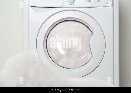 Foam coming out from broken washing machine during laundering Stock Photo