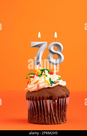 Birthday cake with candle number 78 - Orange foamy background Stock Photo