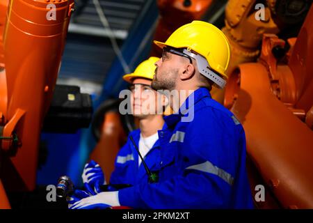 Technicians engineers team checking and maintaining safety of machine Stock Photo
