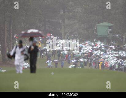 Augusta, United States. 08th Apr, 2023. Patrons walk carrying umbrellas while Russell Henley walks up the 8th fairway while rain falls before the weather halts play in the third round at the Masters tournament at Augusta National Golf Club in Augusta, Georgia on Saturday, April 8, 2023. Photo by John Angelillo/UPI Credit: UPI/Alamy Live News Stock Photo