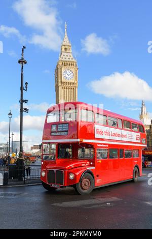 London, UK - March 17, 2023; Iconic London red double decker routemaster bus in front of Elizabeth Tower known for bell Big Ben Stock Photo