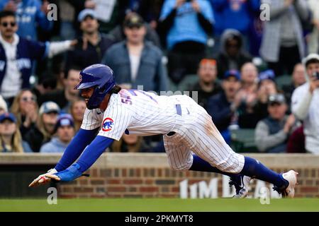 Chicago Cubs' Dansby Swanson slides safely into third base during