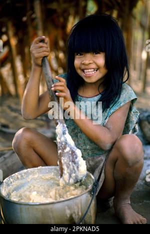 Shipibo Indian girl preparing food in village on shores of Ucayali River, Peru. Shipibo language belongs to the Panoan family. Stock Photo