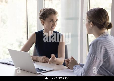 Positive confident mentor training young student, intern Stock Photo