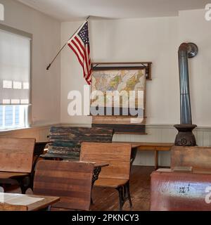Interior view of a restored antique, one room schoolhouse, showing wall maps and student desks. Stock Photo