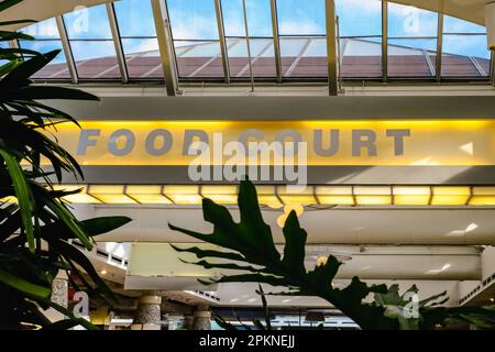 Neon sign read Food Court above the hallway in the shopping mall. Food court in a big shopping centre. Nobody, street photo, selective focus Stock Photo