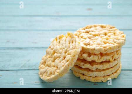 Corn round crispbread, crunchy multigrain cereal seeds on blue wooden background, . Top view Stock Photo