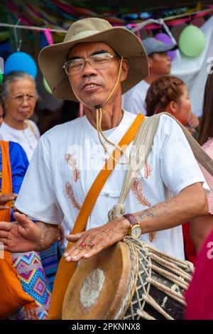 Pai,Northern Thailand-April 4th 2023: One of many percussionists and musicians in the passing crowd,at the colorful Buddhist celebration,where boys ar Stock Photo