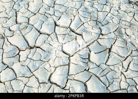 Texture, background of dry cracked earth ground. Deep cracks in land as symbol of hot climate and drought. Global shortage of water on planet. Concept Stock Photo