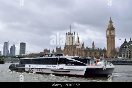 Uber Boat by Thames Clipper river bus service vessel Mercury Clipper on the River Thames in front of the Houses of Parliament in London Stock Photo