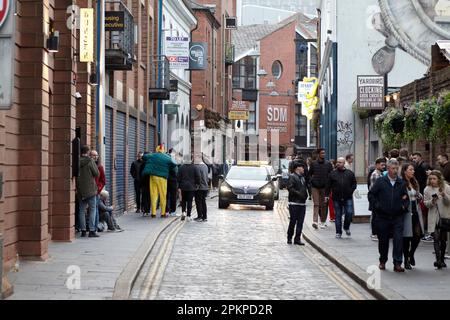 taxis driving through busy hill street on saturday evening cathedral quarter Belfast City Centre, Northern Ireland, UK Stock Photo