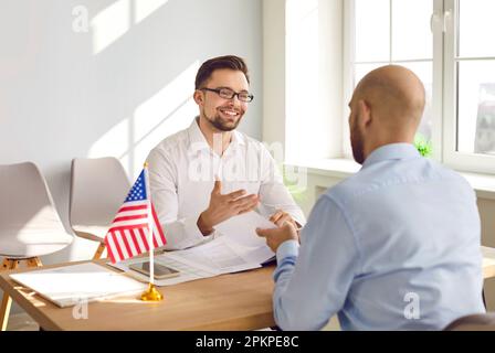 Man sitting in the office of the US embassy with immigration application and having visa interview. Stock Photo