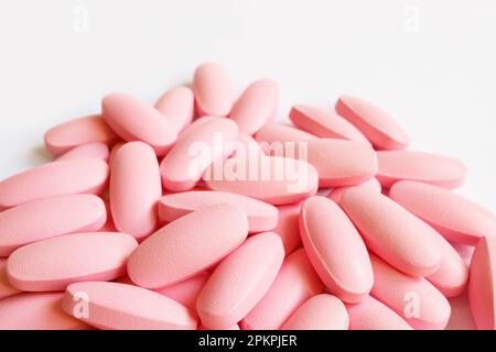 Heap of pastel pink supplement pills on white background with copy space Stock Photo