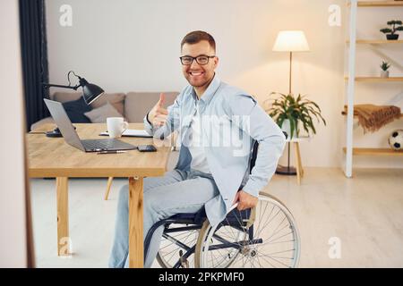 Working on a project from home. Disabled man in wheelchair Stock Photo