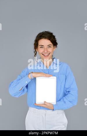 Smiling business woman holding digital tablet computer showing mock up screen. Stock Photo