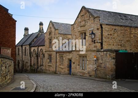 Old buildings line the cobbled street of Owengate in Durham City centre. Captured here looking down from the Palace Green area towards Saddler Street. Stock Photo