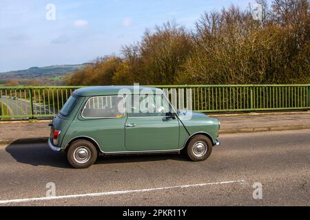 1979 70s seventies Green Austin Morris Mini 850 Super, Petrol 998 cc; crossing motorway bridge in Greater Manchester, UK Stock Photo