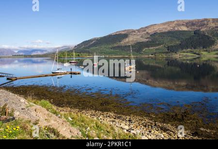 Majestic view of Locleven, reflecting its surrounding mountains on a clear, sunny afternoon in the Western Scottish Highlands Stock Photo