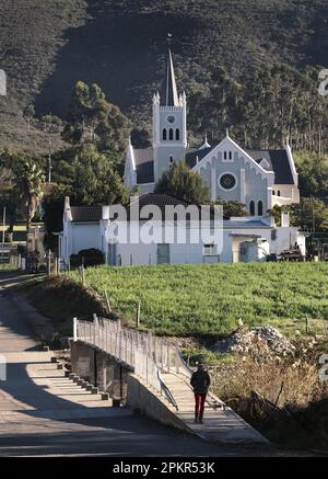 An early walker crosses the small bridge near the Dutch Reformed Church in the Klein Karoo village of Barrydale. Stock Photo