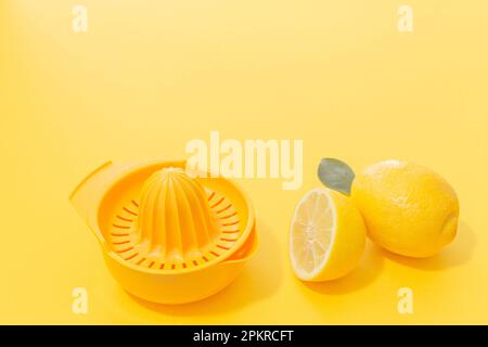 Lemons and yellow lemonade plastic strainer on yellow Background. Minimal concept. Stock Photo