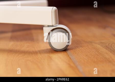 Office chair wheel on the floor of a business workplace. Close up Stock Photo