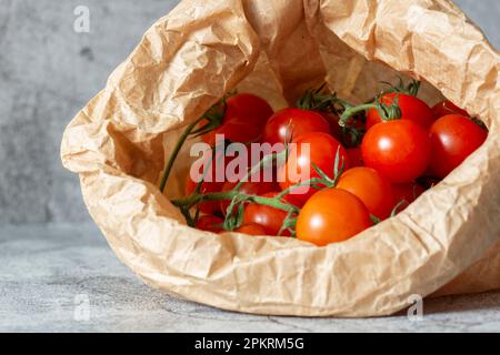 Cherry tomatoes in a brown paper bag. Eco friendly sustainable biodegradable plastic free packaging concept Stock Photo