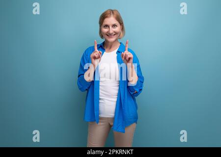 smart mature woman thinking brilliant idea on blue background with copyspace Stock Photo