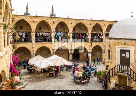 Büyük Han, Great Inn, is one of the main tourist attractions of Nicosia. The old caravanserai consists of two floors. In the lower part of the square complex there are cafes and restaurants. Since 2004, the Coffee Club meets here weekly. Caravanserai Büyük Han in Nicosia, Cyprus Stock Photo