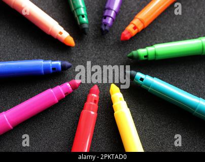 Multi Colored Markers Laid Out In Circle Isolated On Black Angle View Stock Photo