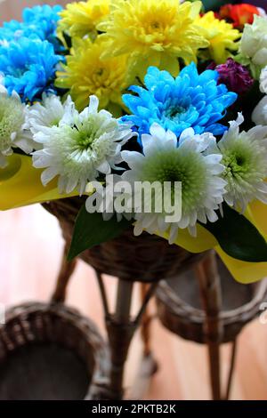 Delicate holiday bouquet wrapped in bright floral paper on a blue  background Stock Photo - Alamy