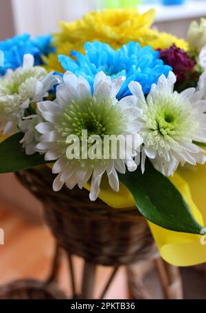 Delicate holiday bouquet wrapped in bright floral paper on a blue  background Stock Photo - Alamy