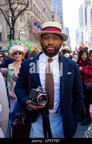 New York, NY, USA. 9th Apr, 2023. Manhattan's Fifth Avenue fills with colorfully costumed and elaborately hatted celebrants for the annual Easter Parade and Bonnet Festival. A dapper man in a straw boater carries a Rolleiflex 66 medium format film camera. Credit: Ed Lefkowicz/Alamy Live News Stock Photo