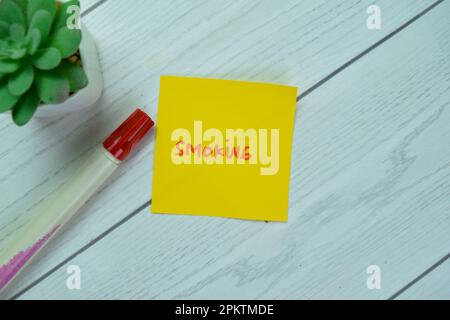 Concept of Smoking write on sticky notes isolated on Wooden Table. Stock Photo