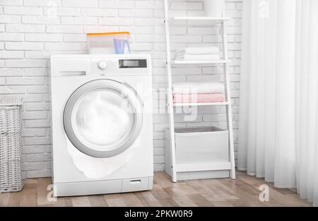 Foam coming out from broken washing machine during laundering in room Stock Photo