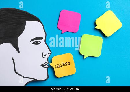 Notes with word Censored and man's head cutout on light blue background, flat lay Stock Photo