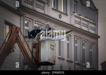 Picture of a group of two men on an aerial lift platform installing christmas decorations and preparing the nye holiday celebrations. Stock Photo