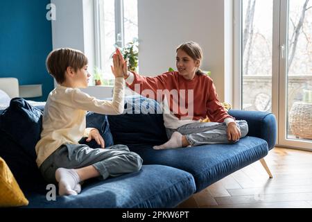 Older sister spending time with younger brother at home Stock Photo