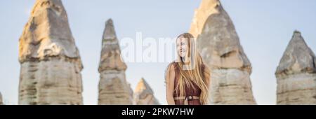 BANNER, LONG FORMAT Woman tourist on background of Unique geological formations in Love Valley in Cappadocia, popular travel destination in Turkey Stock Photo