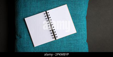Open blank notepad on top of blue color pillow case. Copy space. Stock Photo