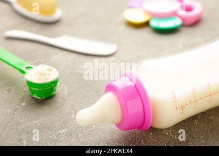Baby milk with toys on grey background. Top view Stock Photo