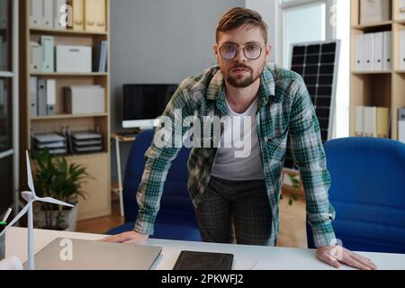 Portrait of sustainable energy engineer standing at his desk Stock Photo