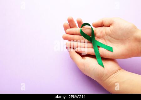 female holding green organ transplant awareness ribbon Stock Photo - Alamy