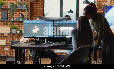 Team of diverse women brainstorming ideas to develop industrial clamp, doing teamwork to create mechanical prototype with cad software. Young technicians working in manufacturing industry. Stock Photo