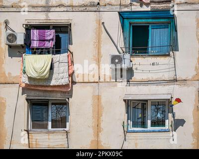 Old worn out communist apartment bulding in Bucharest, Romania. Old clothes laundry left to dry on the balcony. Stock Photo