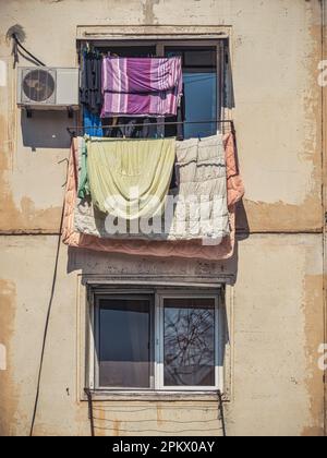 Old worn out communist apartment bulding in Bucharest, Romania. Old clothes laundry left to dry on the balcony. Stock Photo