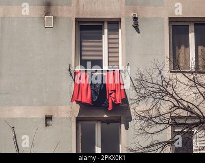 Old worn out communist apartment building in Bucharest, Romania. Old clothes laundry left to dry on the balcony. Stock Photo