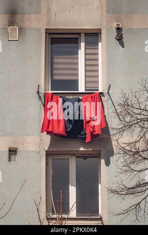 Old worn out communist apartment building in Bucharest, Romania. Old clothes laundry left to dry on the balcony. Stock Photo