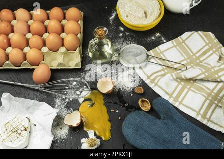 A broken egg on the table, a mess at the cook's workplace. Chicken egg dropped on the table. Place for text Stock Photo