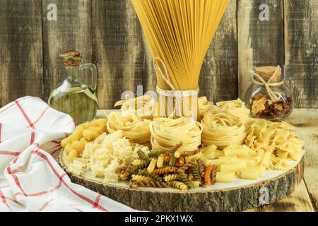 Assortment of dried pasta, on a wooden background. Mix of different and raw pasta, Side view. Place for text Stock Photo